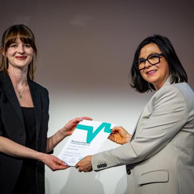 Dr. Barbara Hollunder (links) nimmt den DGKN-Nachwuchspreis für Funktionelle Bildgebung von Kongresspräsidentin Prof. Susanne Schubert-Bast entgegen